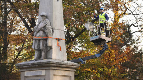 A worker stands on a crane during dismantling of a Red Army monument in Glubczyce, Poland, Thursday, Oct. 27, 2022.