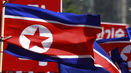 FILE PHOTO: North Korean flags are carried during a celebration of the nation's 73rd founding anniversary in Pyongyang, North Korea, September 9, 2021.