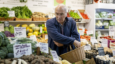A man shops in a greengrocers in Cardiff Market in Cardiff, United Kingdom.