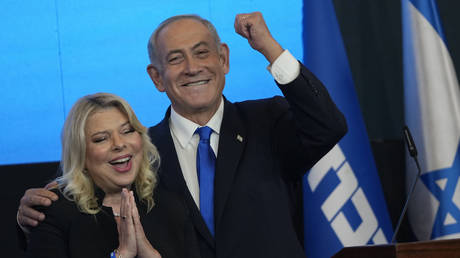 Likud party leader Benjamin Netanyahu and his wife Sara react to first exit poll results for the Israeli Parliamentary election at his party's headquarters in Jerusalem, November 2, 2022.