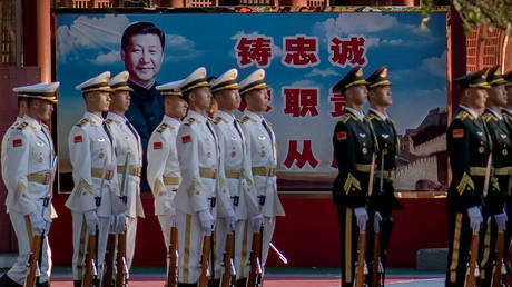 FILE PHOTO. Military personnel stand in formation next to a portrait of China's President Xi Jinping.