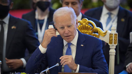 Joe Biden adjusts his earpiece during the ASEAN - US summit in Phnom Penh, Cambodia, November 12, 2022