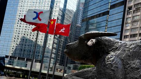 FILE PHOTO: The Chinese and Hong Kong flags flutter outside the Exchange Square complex, which houses the Hong Kong Stock Exchange (HKEX).
