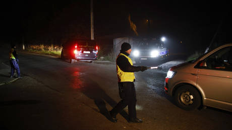 A police officer checks a vehicle outside a grain depot in the Polish village of in Przewodow where a missile explosion killed two people.