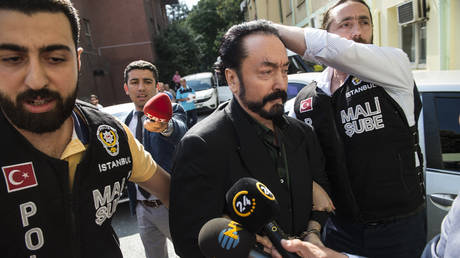 FILE PHOTO: Turkish police officers escort televangelist Adnan Oktar (C) on July 11, 2018, in Istanbul, as he is arrested on fraud charges.