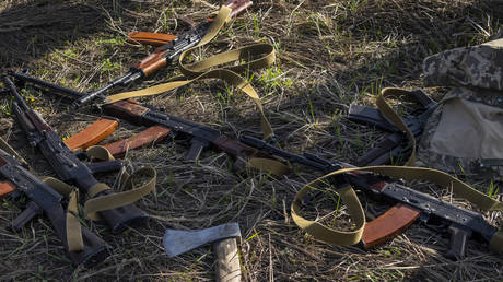 Rifles lay in a field where Ukrainian soldiers dig a trench in Bucha, Ukraine, April 14, 2022