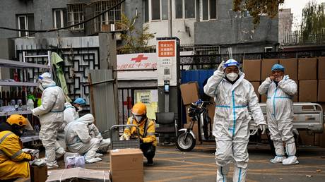 Health workers guard the entrance of a residential area under lockdown due to Covid-19 coronavirus restrictions in Beijing.