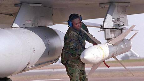 FILE PHOTO: A US airman secures a HARM missile an a combat jet.