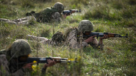 Ukrainian recruits aim their unloaded AK-47 rifles during a combat training course.