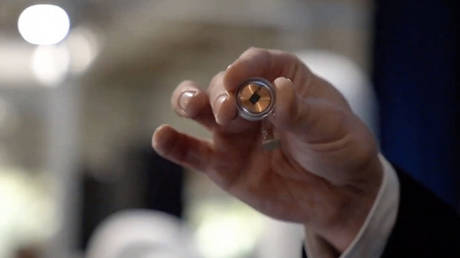 A Neuralink disk implant held by Elon Musk during the presentation on August 28, 2020.
