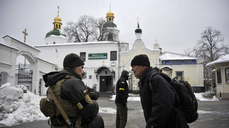 A Ukraine's Security Service (SBU) serviceman talks with a visitor in front of Kiev Pechersk Lavra monastery on November 22, 2022.