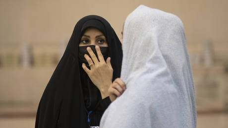 FILE PHOTO: Two Iranian veiled women talk to each other at a prayer hall in the Imam Khomeini Grand mosque in downtown Tehran.