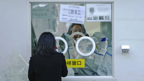 A man has his routine COVID-19 throat swab at a coronavirus testing site in Beijing, Tuesday, Dec. 6, 2022.