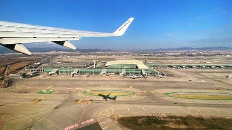 FILE PHOTO: El Prat airport in Barcelona, Spain is seen from the window of a passenger plane as it takes off.