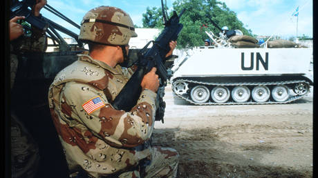 FILE PHOTO. A United Nations soldier kneels beside a vehicle June 6, 1993 in Mogadishu, Somalia.