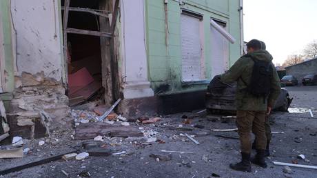 Men study the damage to the Donetsk City Youth Center, which was damaged as a result of artillery shelling.