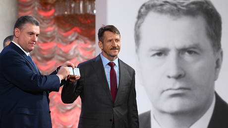 The head of the LDPR faction Leonid Slutsky hands a party ticket to the new party member Viktor Bout (right) at the All-Russian rally dedicated to the party's birthday, in the Column Hall of the House of Unions in Moscow.