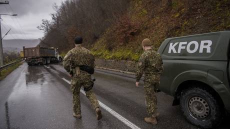 NATO soldiers inspect a road barricade set up by ethnic Serbs near the town of Zubin Potok in Kosovo, December 11, 2022
