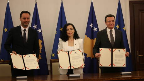 Left to right: Glauk Konjufca, Vjosa Osmani and Albin Kurti sign the application for Kosovo's membership in the European Union in Pristina, December 14, 2022.