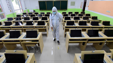 A staff member sprays disinfectant in a classroom at a school in China. 
AFP / STR