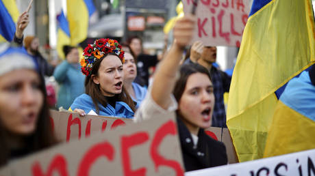 Protestors hold signs and chant during a demonstration outside of an EU summit in Brussels, Friday, Oct. 21, 2022.