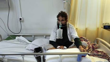 FILE PHOTO: A Covid-19 patient sits on a bed at a hospital in Kabul, Afghanistan, February 7, 2022