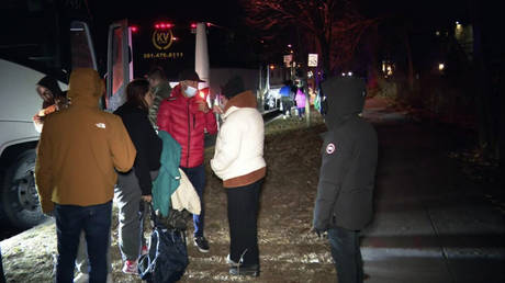 Migrant families get on to a bus to transport them from near the Vice President's residence to an area church after they arrived in Washington, December 24, 2022