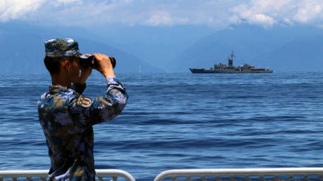 A soldier looks through binoculars during combat exercises and training of the navy of the Eastern Theater Command of the Chinese People's Liberation Army (PLA) in the waters around the Taiwan Island.