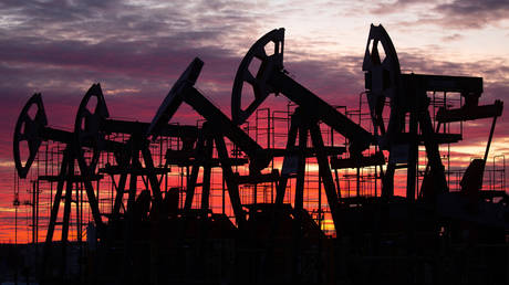 FILE PHOTO: Oil pumping jacks in an oil field at sunset in Russia.