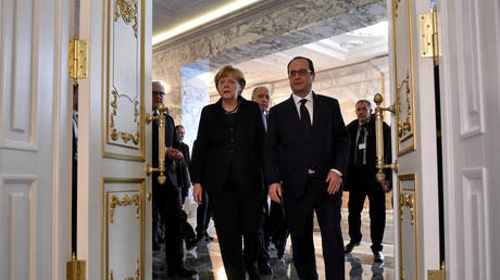 Former German Chancellor Angela Merkel and former French President Francois Hollande arrive in Minsk, Belarus for a peace summit aimed at ending the conflict in Ukraine, February 2015.