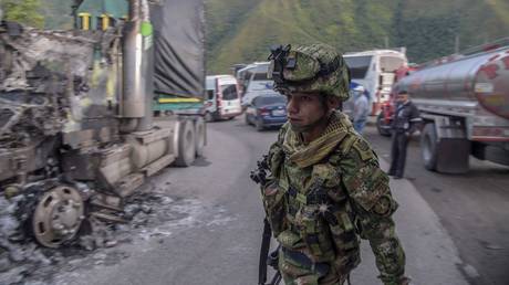 A Colombian soldier looks at a truck burned by militants on the Ocaña-Sardinata road in northeast Colombia, November 22, 2022