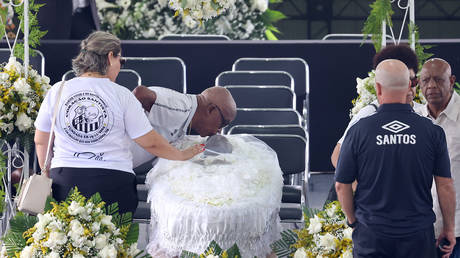 A mourner kisses Pele's head at his funeral in Urbano Caldeira Stadium on January 02, 2023 in Santos, Brazil