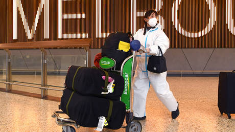 International travellers wearing personal protective equipment arrive at Melbourne's Tullamarine Airport on November 29, 2021.