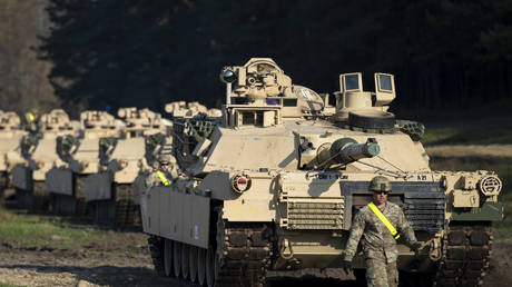 FILE PHOTO: A member of the US Army walks near Abrams battle tanks after arriving at the Pabrade railway station near Vilnius, Lithuania, October 21, 2019