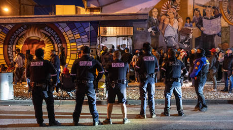 Police watch as immigrants enter a shelter on January 6, 2023 in El Paso, Texas