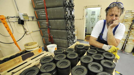 FILE PHOTO. A worker leans on cluster munitions at a decommissioning facility in Germany.