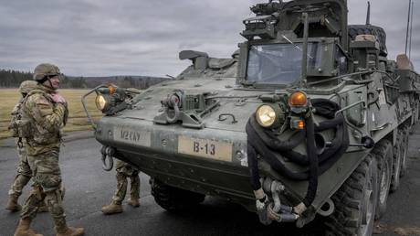FILE PHOTO: US soldiers stand next to a Stryker combat vehicle in Vilseck, Germany, February 9, 2022