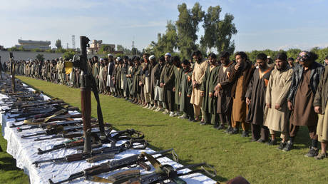 FILE PHOTO: Members of the Islamic State (IS) group stand alongside their weapons, following they surrender to Afghanistan's government.