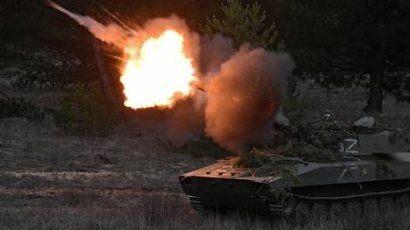FILE PHOTO: Russian servicemen fire a 2S1 Gvozdika self-propelled howitzer.
