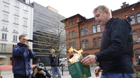 FILE PHOTO:  Danish-Swedish right-wing extremist Rasmus Paludan, who leads the anti-immigration Hard Line party in Denmark, burns a Koran in Stockholm, Sweden, May 1, 2022.