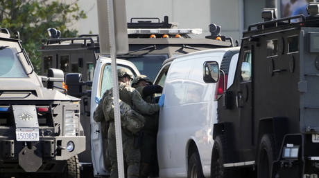 Members of a SWAT team enter a van and look through its contents in Torrance California, January 22, 2023