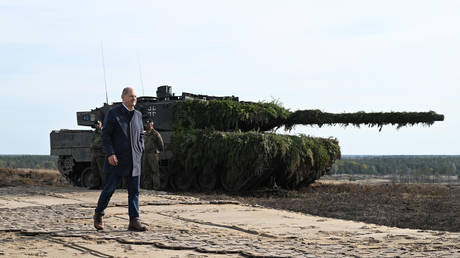 FILE PHOTO. German Chancellor Olaf Scholz walks past a Leopard 2 main battle tank.