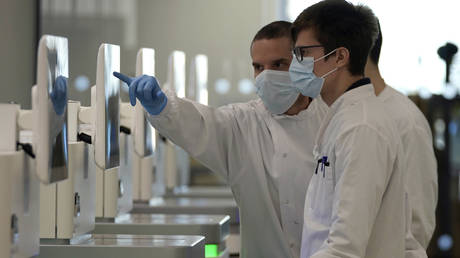 FILE PHOTO: Research assistants watch sequencing machines analyzing the genetic material of Covid-19 cases at the Wellcome Sanger Institute in Cambridgeshire, England, January 7, 2022