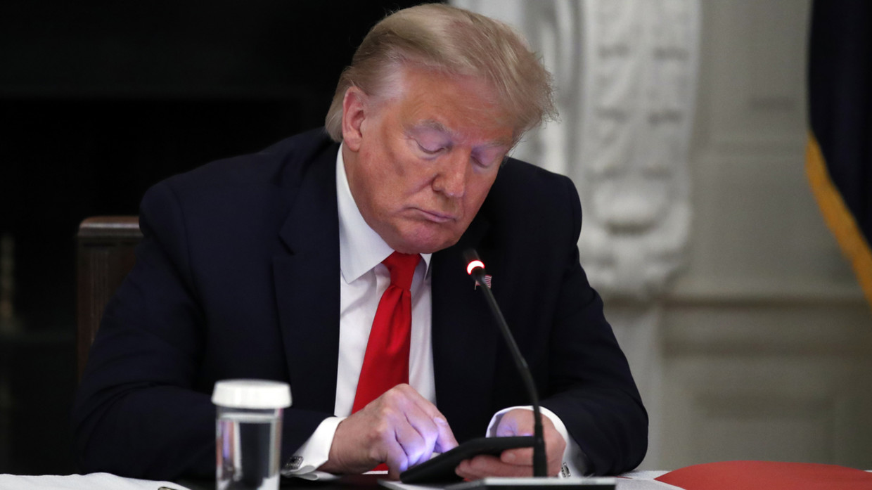 Donald Trump looks at his phone during a meeting with governors at the White House in Washington, DC, June 18, 2020