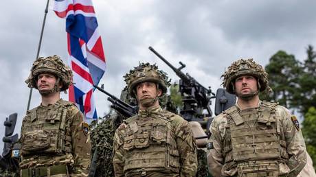 FILE PHOTO: British soldiers stand in front of a military vehicle during a press conference of the Polish and Lithuanian president following a joint visit of the NATO Multinational Division North East mobile command center.