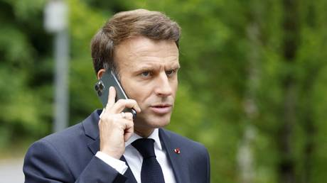 FILE PHOTO: Emmanuel Macron talks on his mobile phone at the end of the G7 summit at Elmau Castle, Germany, June 28, 2022
