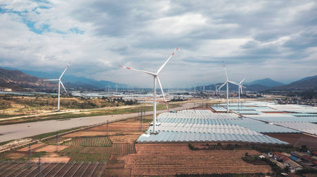 A large wind farm with more than 100 wind turbines in a beautiful valley is producing a big amount of Clean and green energy, helping carbon reduction.