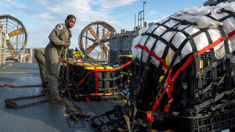 A sailor aboard a US Navy vessel prepares to transport material recovered from a Chinese balloon that was shot down off the coast of South Carolina earlier this month.