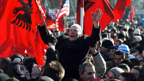FILE PHOTO. Kosovars wave flags and shout slogans after Kosovo's declaration of independence on February 17, 2008.