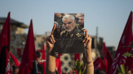 FILE PHOTO. An Iranian mourner holds-up a portrait of Major General Qasem Soleimani.